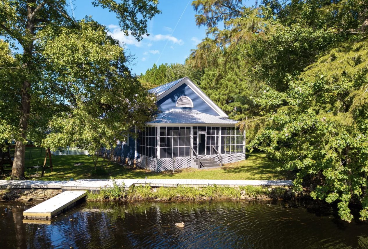 Blue waterfront cottage with a screened porch, dock, and lawn on a creek near Edenton, NC